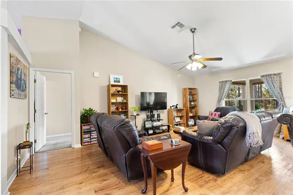 a living room with furniture a large window and a wooden floor