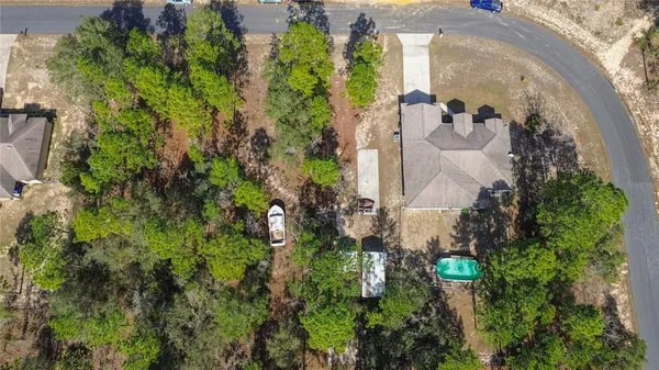 an aerial view of residential house with outdoor space and trees all around