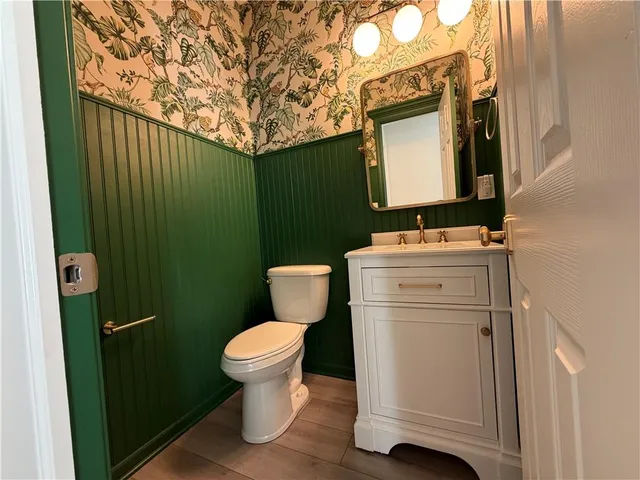 a bathroom with a toilet sink and mirror