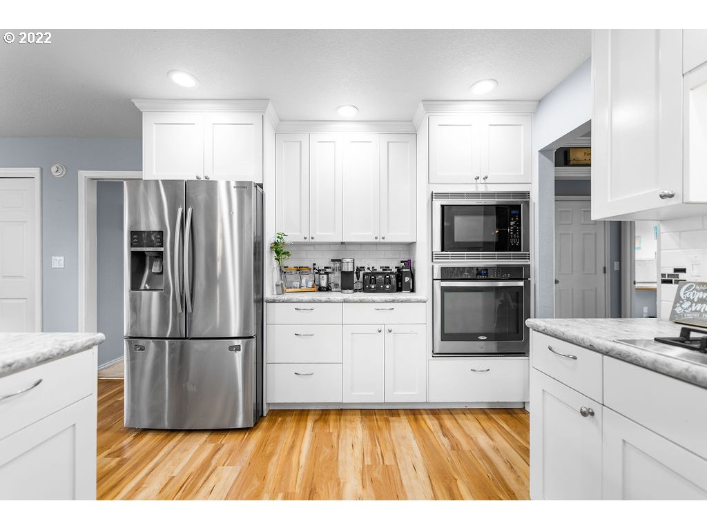 1908 North 4th Way Ridgefield, WA 98642 - Photo 12 of 32 a kitchen with granite countertop a refrigerator stove and sink