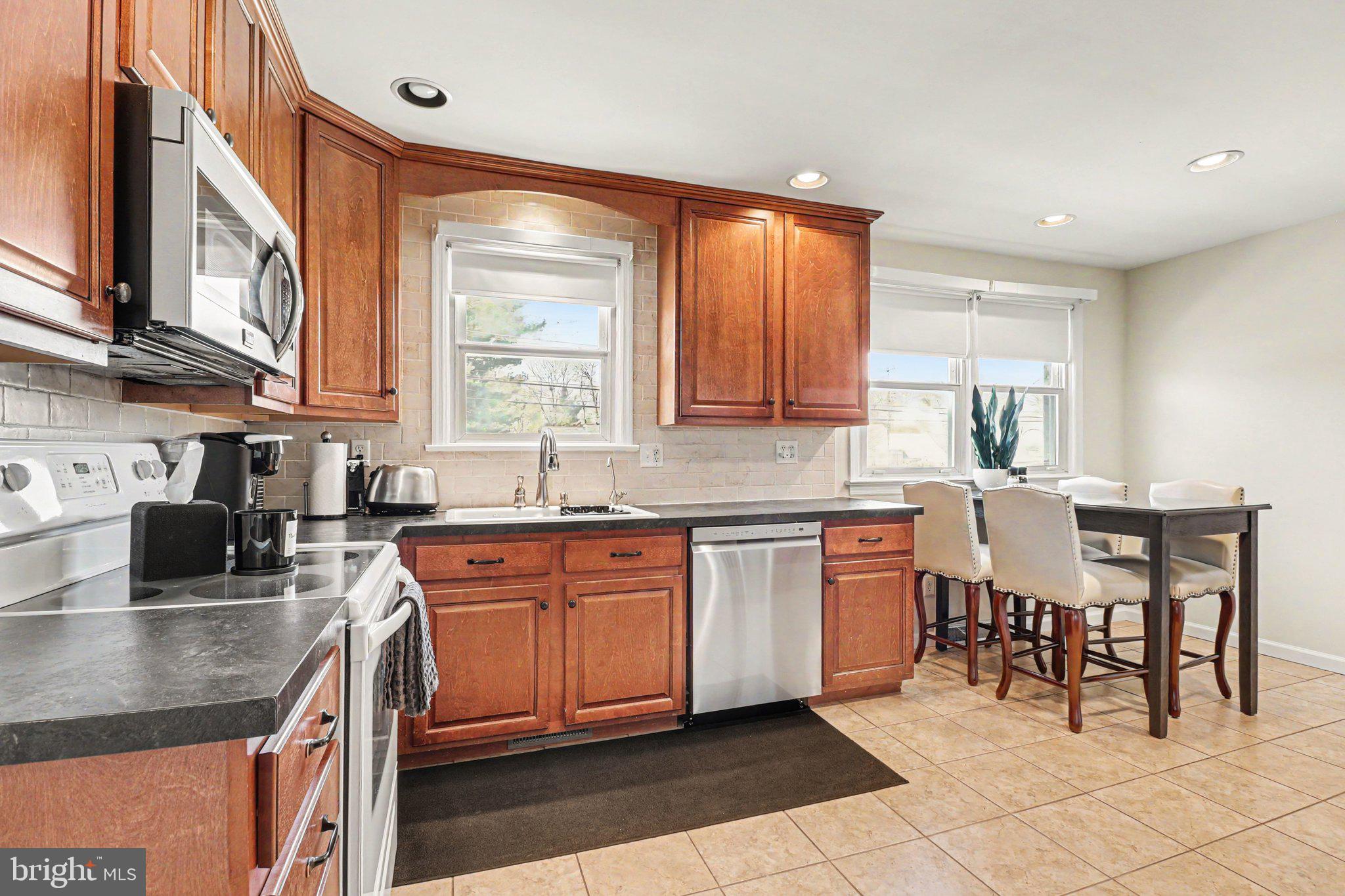 913 Stehman Road Millersville, PA 17551 - Photo 6 of 38 a kitchen with stainless steel appliances granite countertop a sink a stove a dining table and chairs