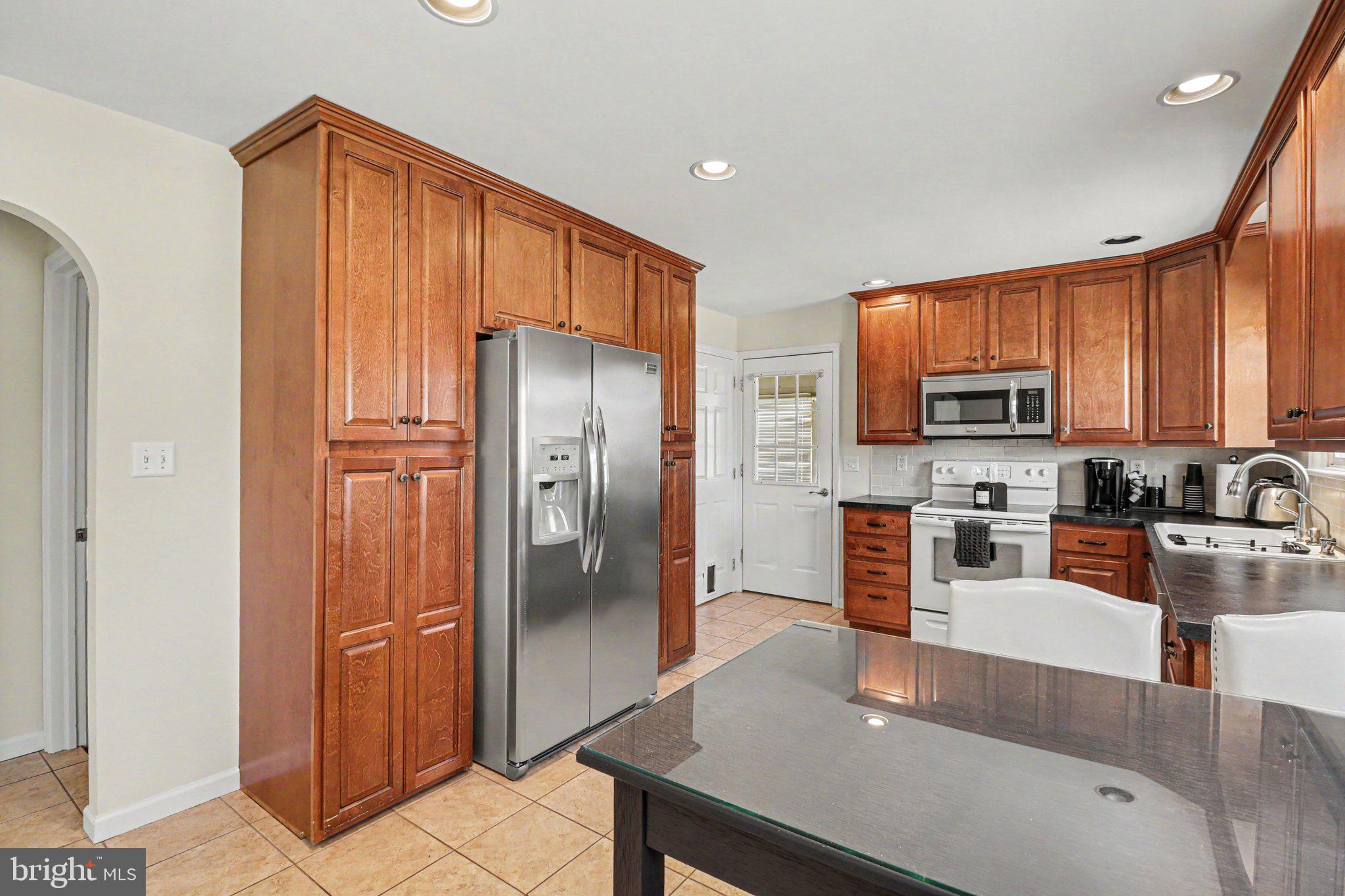 913 Stehman Road Millersville, PA 17551 - Photo 7 of 38 a kitchen with stainless steel appliances granite countertop a refrigerator a stove top oven and granite countertops with wooden floor