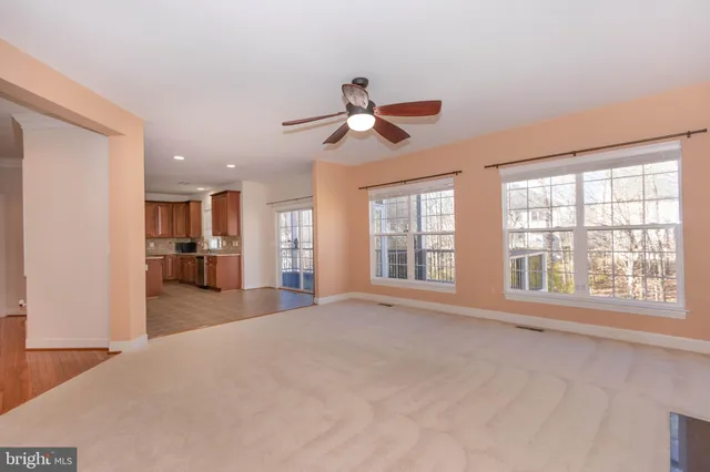 a view of an empty room with a window and fireplace
