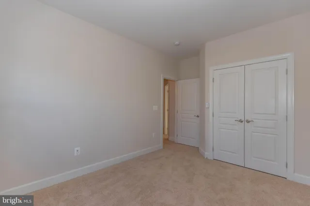 a view of an empty room with a window and closet area