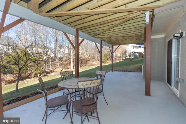 a patio with table and chairs and potted plants