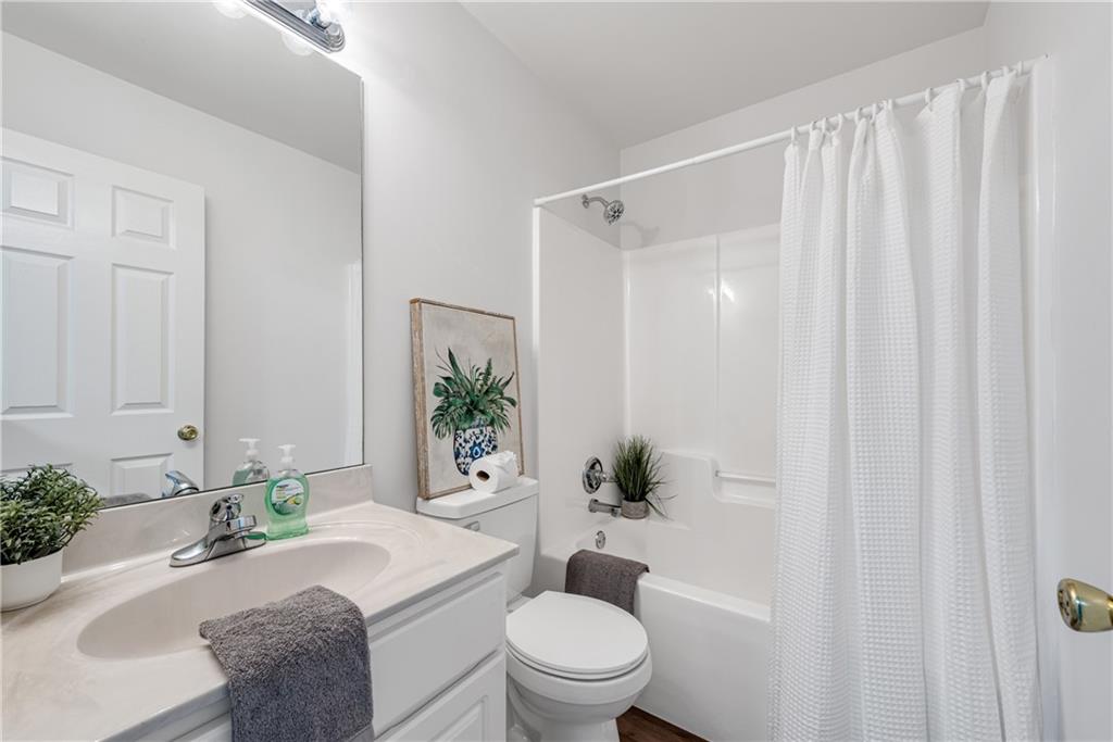 125 Pine Ridge Trace Athens, GA 30605 - Photo 21 of 28 a bathroom with a granite countertop sink a toilet a mirror and shower curtain