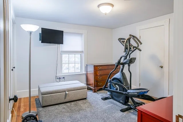 a living room with furniture and a gym machine