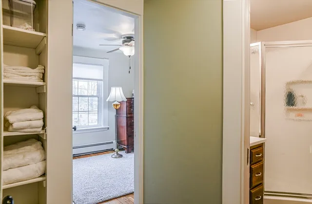 a view of a hallway with bathroom and wooden floor