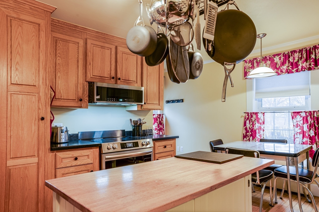 42 Bisson Street Beverly, MA 01915 - Photo 6 of 28 a kitchen with stainless steel appliances kitchen island granite countertop a stove a sink and a microwave
