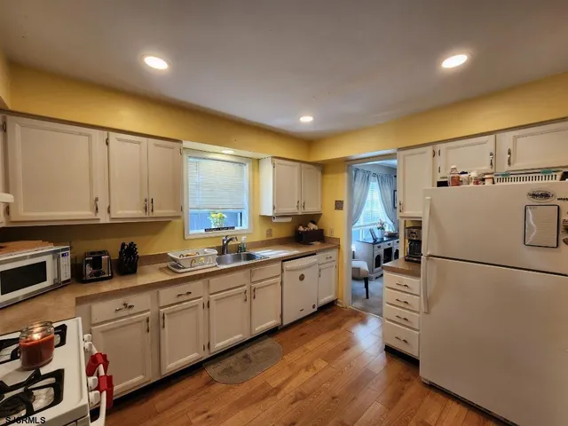 a kitchen with sink refrigerator and cabinets