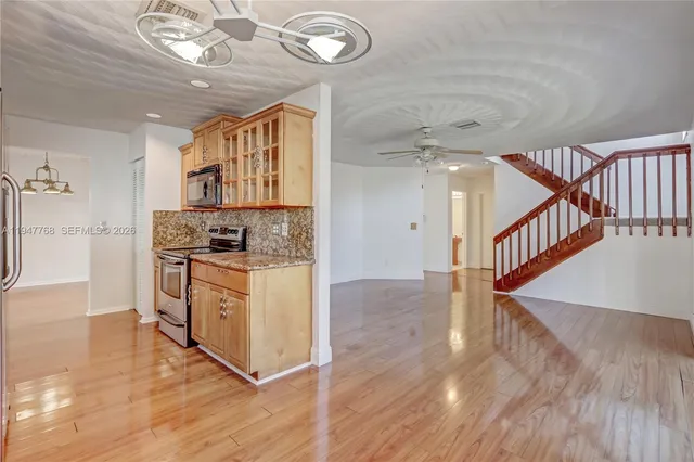 a kitchen with stainless steel appliances granite countertop a stove top oven a sink and cabinets