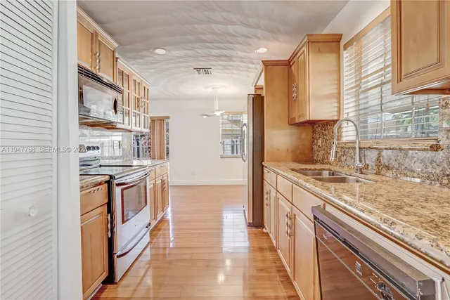 a kitchen with stainless steel appliances granite countertop a stove and a sink