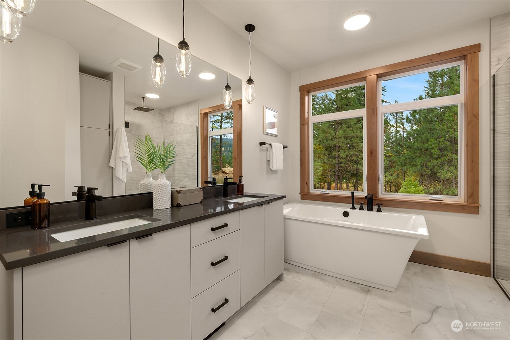 331 Old Grv Trail Ronald, WA 98940 - Photo 27 of 40 a spacious bathroom with a double vanity sink a large mirror and a bathtub next to a window