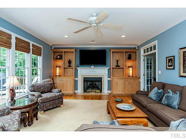 4724 Sharpstone Lane Raleigh, NC 27615 - Photo 8 of 25 a living room with furniture a fireplace and a flat screen tv
