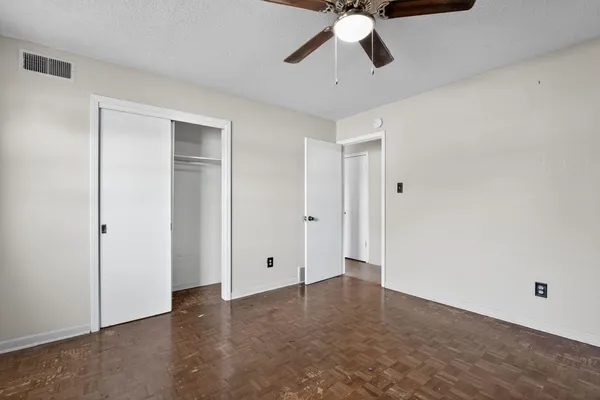 an empty room with closet and mirror