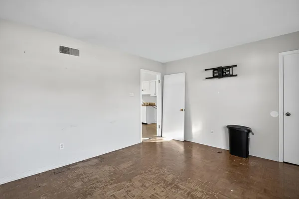 an empty room with ceiling fan and windows