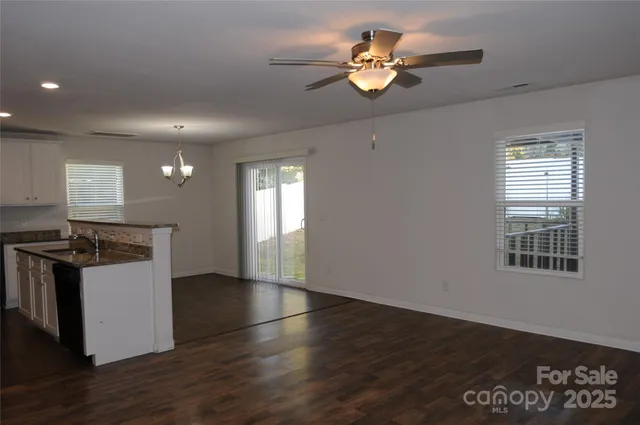 a view of a kitchen with a stove wooden floor and a window