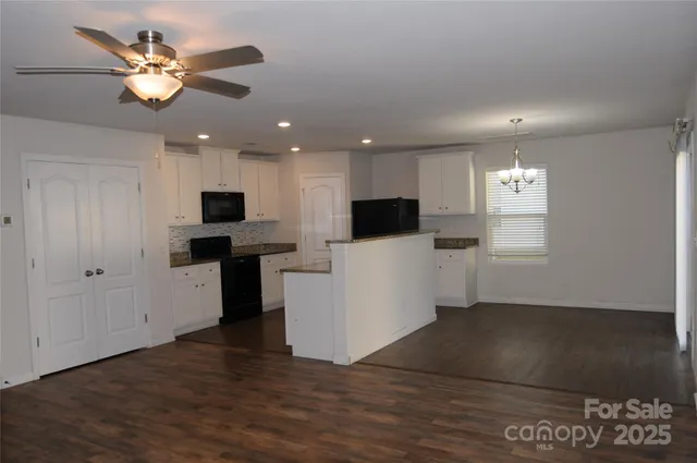 a view of kitchen with microwave and white cabinets