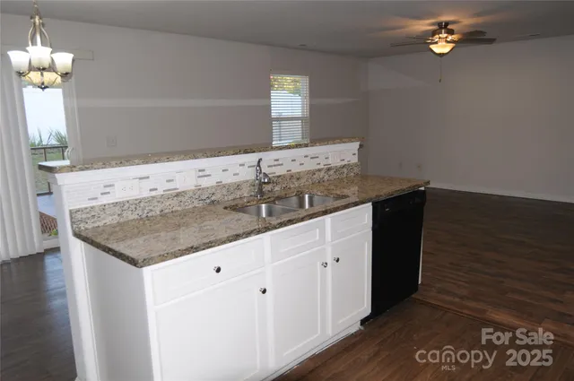 a bathroom with a granite countertop sink a mirror and vanity