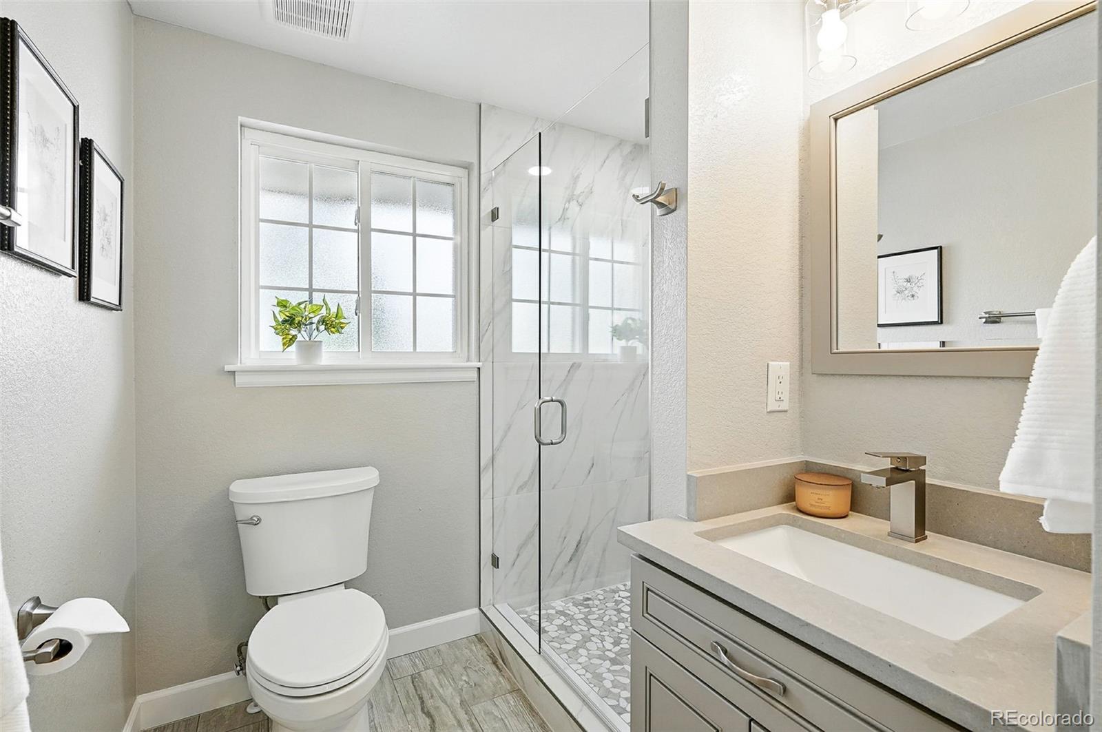 10320 West 35th Avenue Wheat Ridge, CO 80033 - Photo 27 of 46 a bathroom with a granite countertop sink a toilet and shower