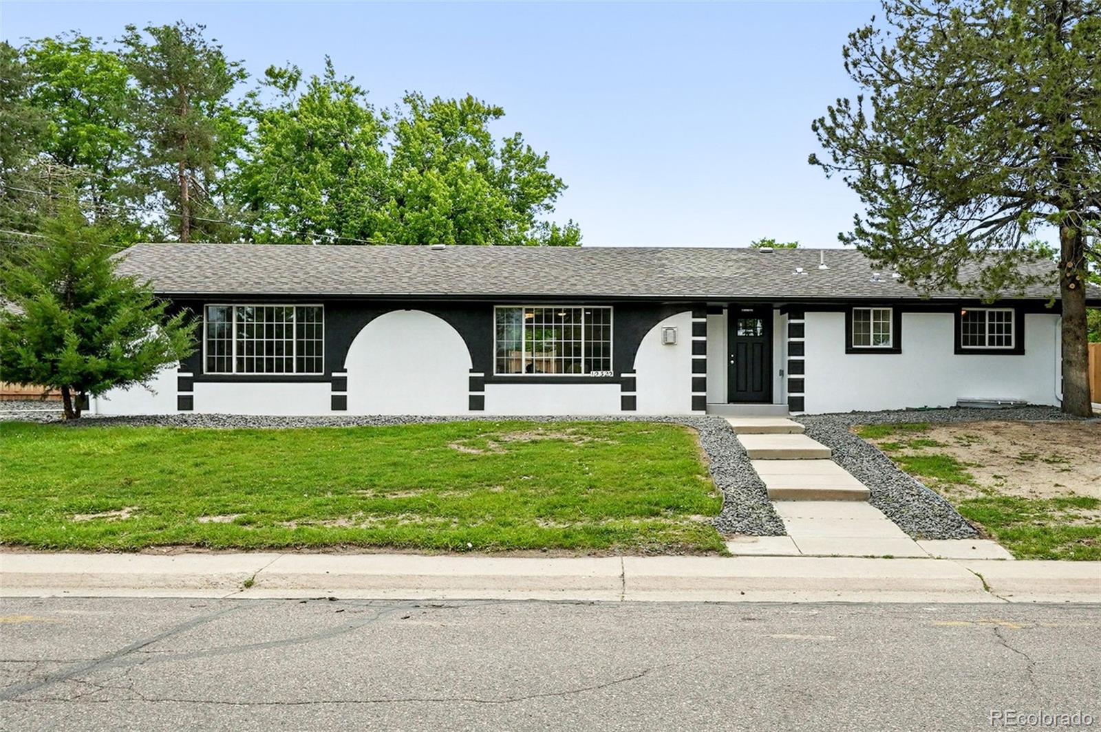 10320 West 35th Avenue Wheat Ridge, CO 80033 - Photo 6 of 46 a front view of a house with a garden and trees