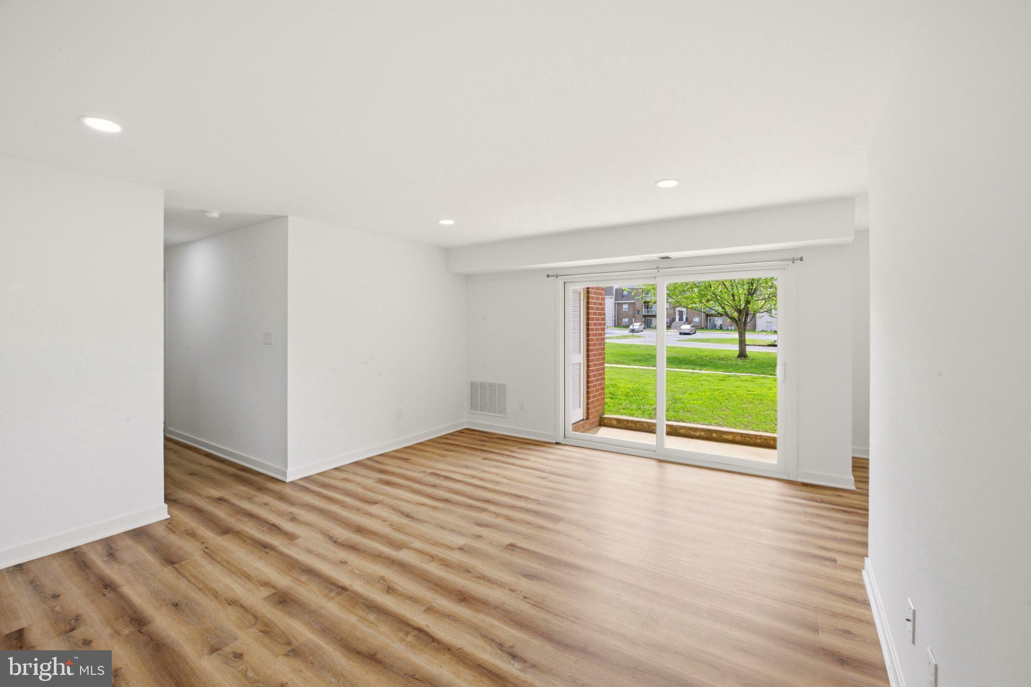 1207 Colony Court, Unit 122 Lebanon, PA 17042 - Photo 1 of 11 a view of an empty room with a window and wooden floor