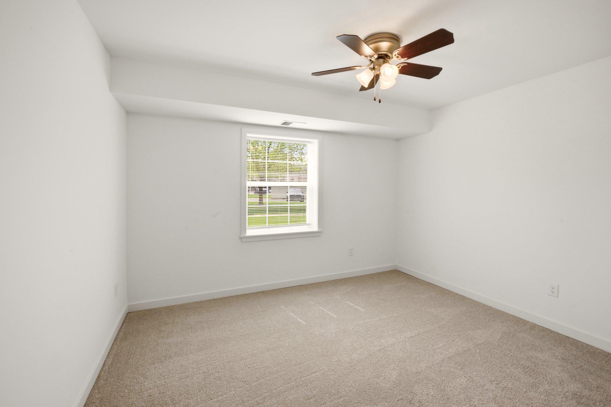 1207 Colony Court, Unit 122 Lebanon, PA 17042 - Photo 8 of 11 an empty room with a window and a ceiling fan