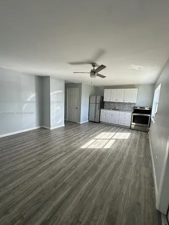 a view of a room with wooden floor and window