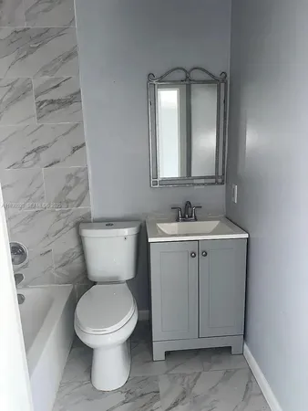 a bathroom with a toilet sink and mirror