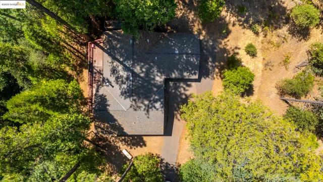 an aerial view of residential houses with outdoor space and trees