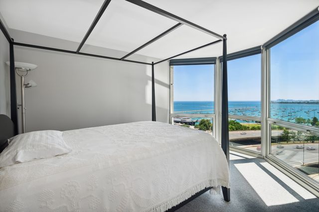 a bedroom with a bed and large windows