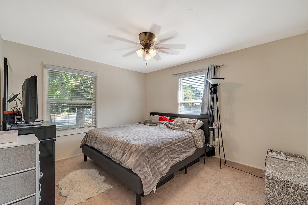 1197 Broadleaf Lane San Jose, CA 95128 - Photo 13 of 29 a bedroom with a bed and a chandelier