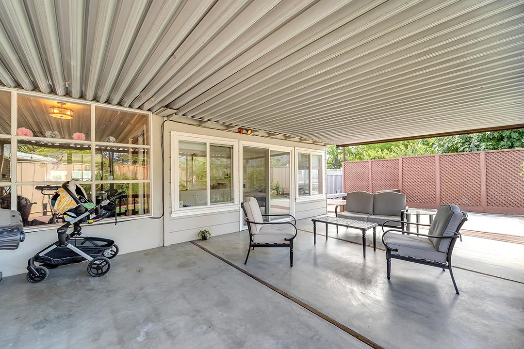 1197 Broadleaf Lane San Jose, CA 95128 - Photo 24 of 29 a view of a patio with table and chairs and floor to ceiling window with wooden fence