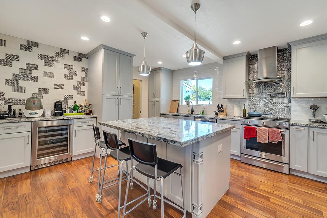 1197 Broadleaf Lane San Jose, CA 95128 - Photo 6 of 29 a kitchen with stainless steel appliances granite countertop a stove and a wooden floors
