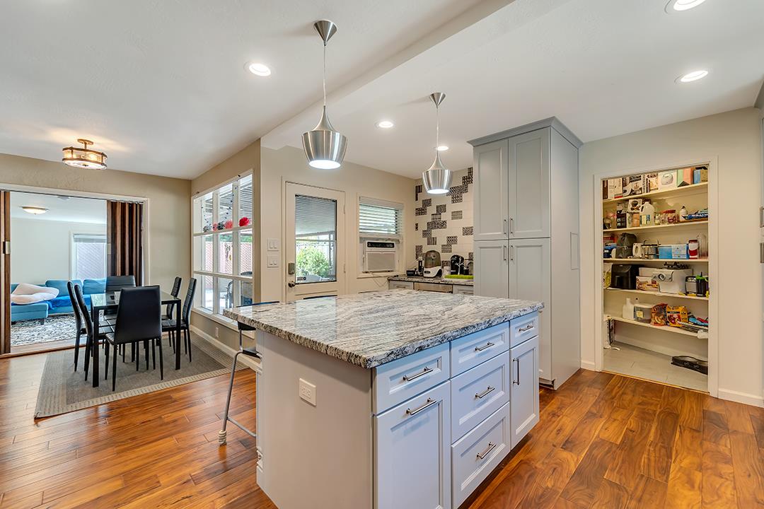1197 Broadleaf Lane San Jose, CA 95128 - Photo 7 of 29 a kitchen with stainless steel appliances granite countertop a kitchen island a stove and a sink