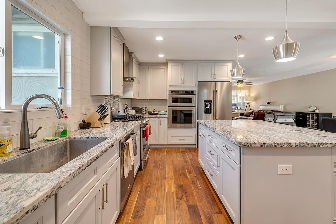 1197 Broadleaf Lane San Jose, CA 95128 - Photo 8 of 29 a large kitchen with granite countertop a large counter top stainless steel appliances and a counter space