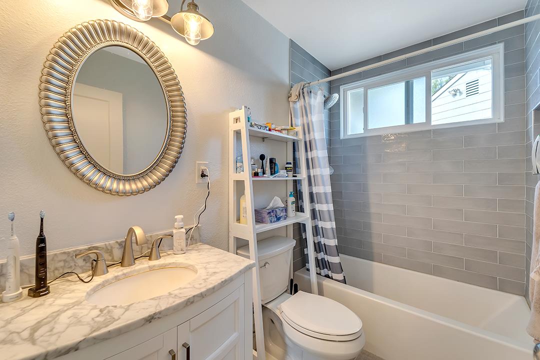 1197 Broadleaf Lane San Jose, CA 95128 - Photo 10 of 29 a bathroom with a granite countertop sink mirror vanity and toilet