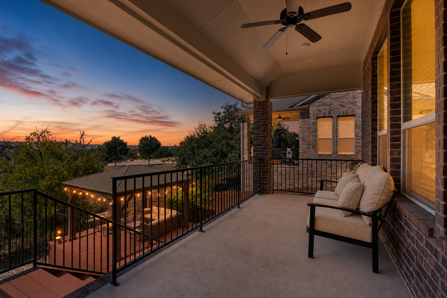 17817 Limestone Spring Lane Austin, TX 78738 - Photo 13 of 15 An elevated covered patio with brick columns overlooks a sunset view and a lower deck.