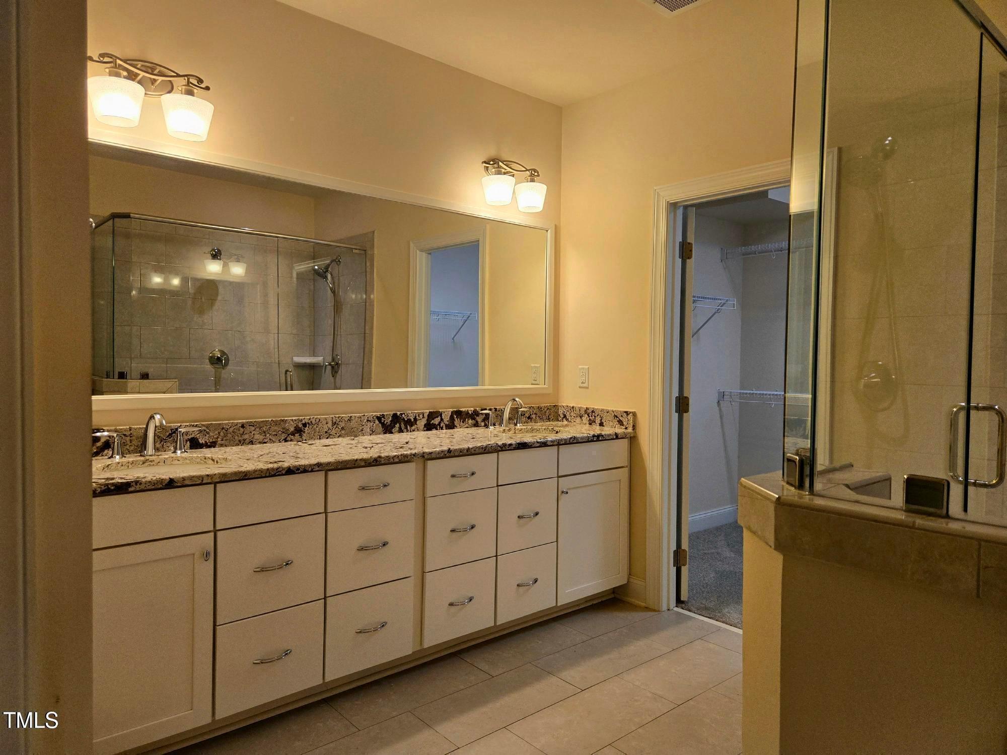 10420 Sablewood Drive, Unit 102 Raleigh, NC 27617 - Photo 11 of 15 a bathroom with a double vanity sink and a mirror