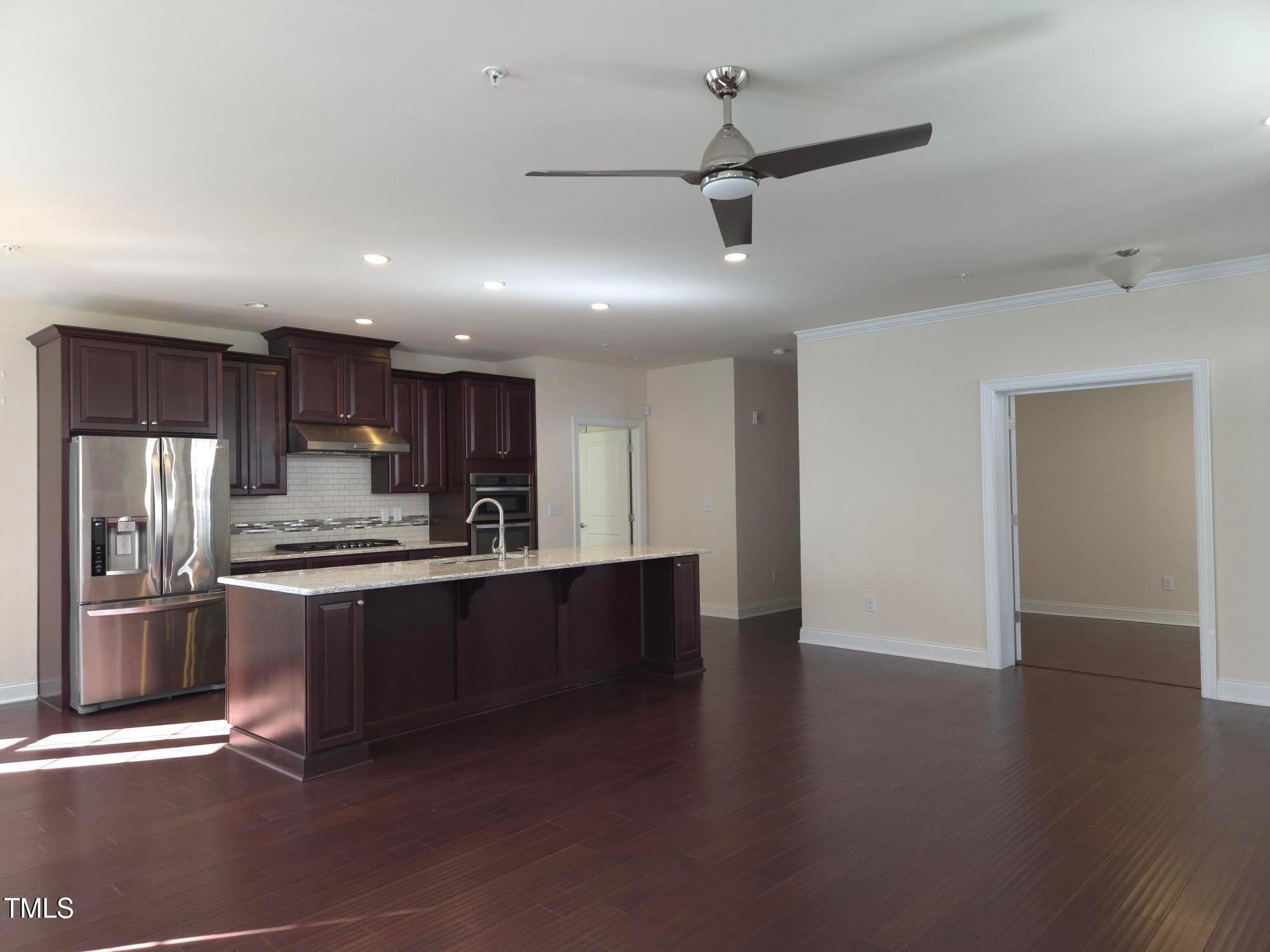 10420 Sablewood Drive, Unit 102 Raleigh, NC 27617 - Photo 4 of 15 a kitchen with stainless steel appliances granite countertop a refrigerator a sink a stove and a microwave