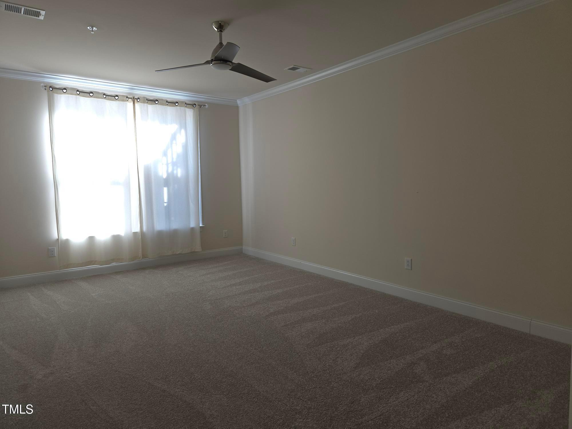 10420 Sablewood Drive, Unit 102 Raleigh, NC 27617 - Photo 8 of 15 an empty room with windows and chandelier fan