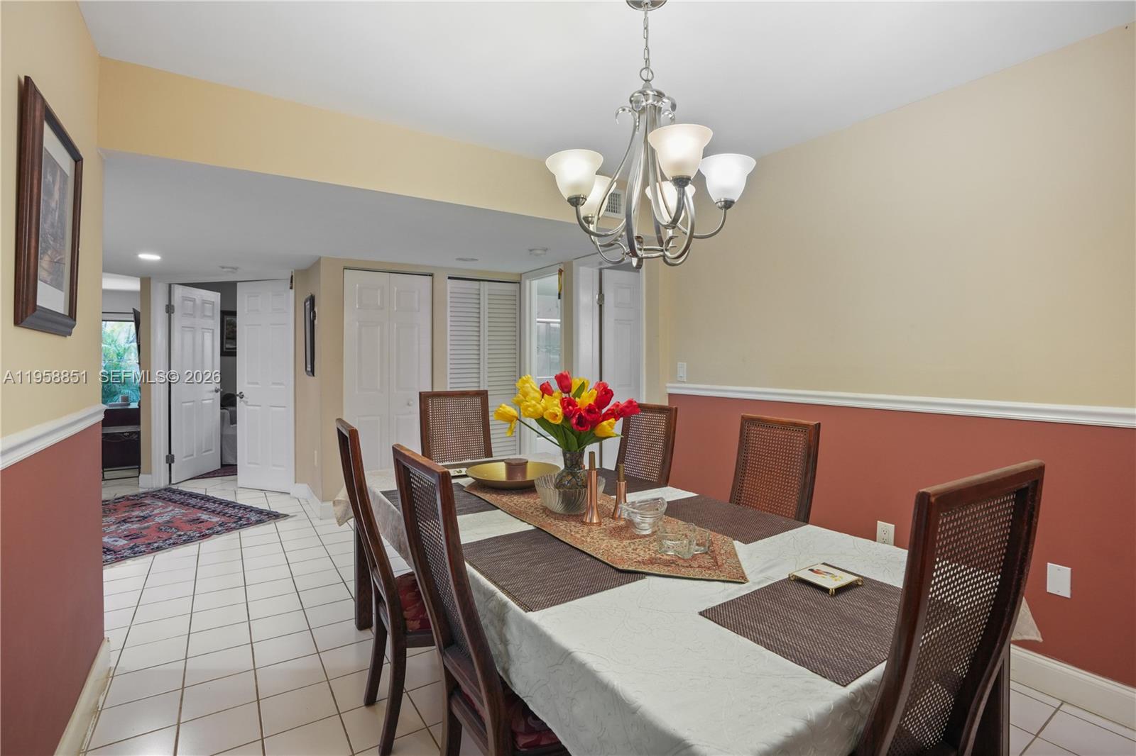 12930 Southwest 88th Terrace, Unit A104 Miami, FL 33186 - Photo 15 of 38 a view of a dining room with furniture wooden floor and chandelier