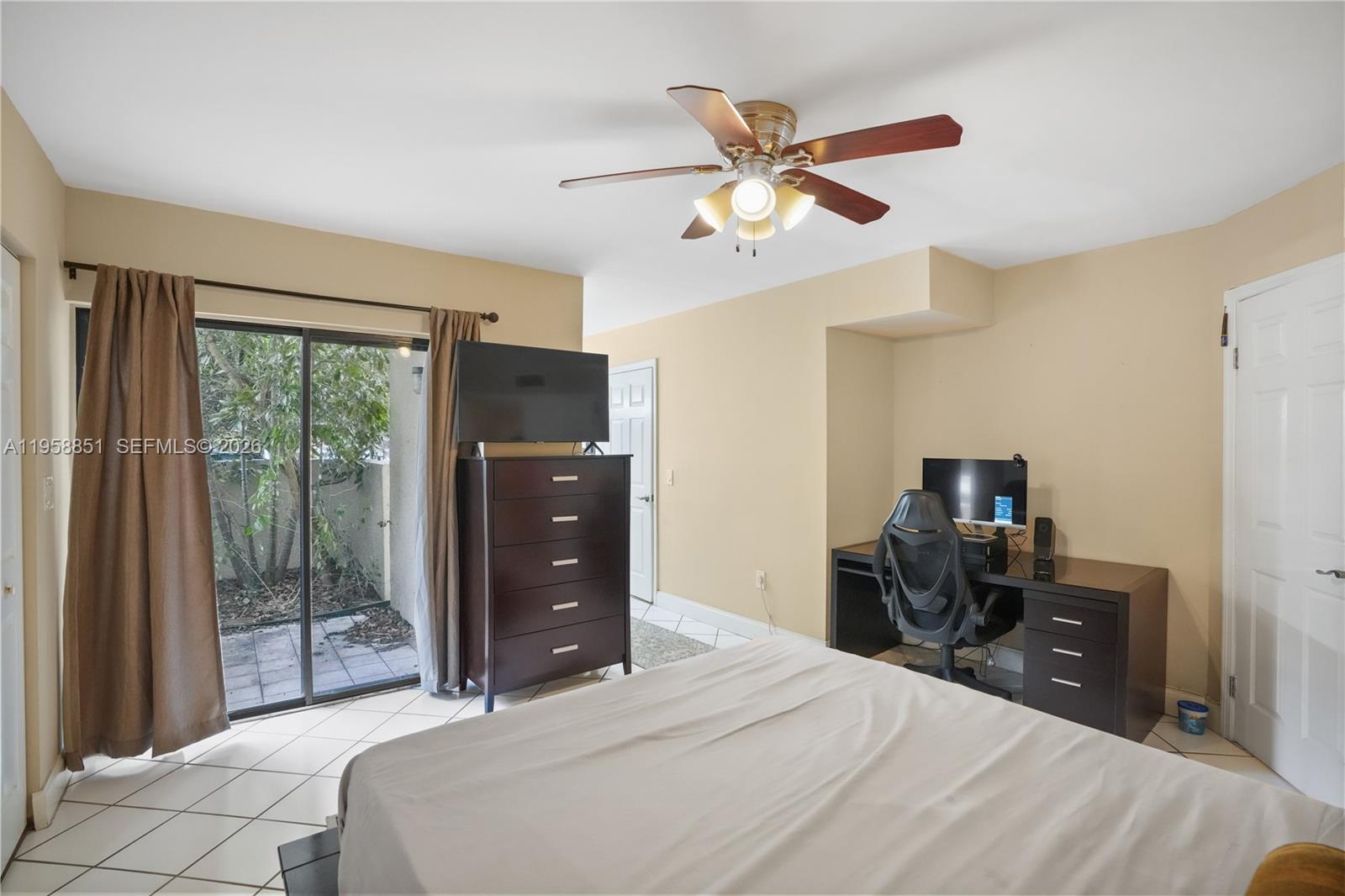 12930 Southwest 88th Terrace, Unit A104 Miami, FL 33186 - Photo 18 of 38 a bedroom with a bed and a flat tv screen