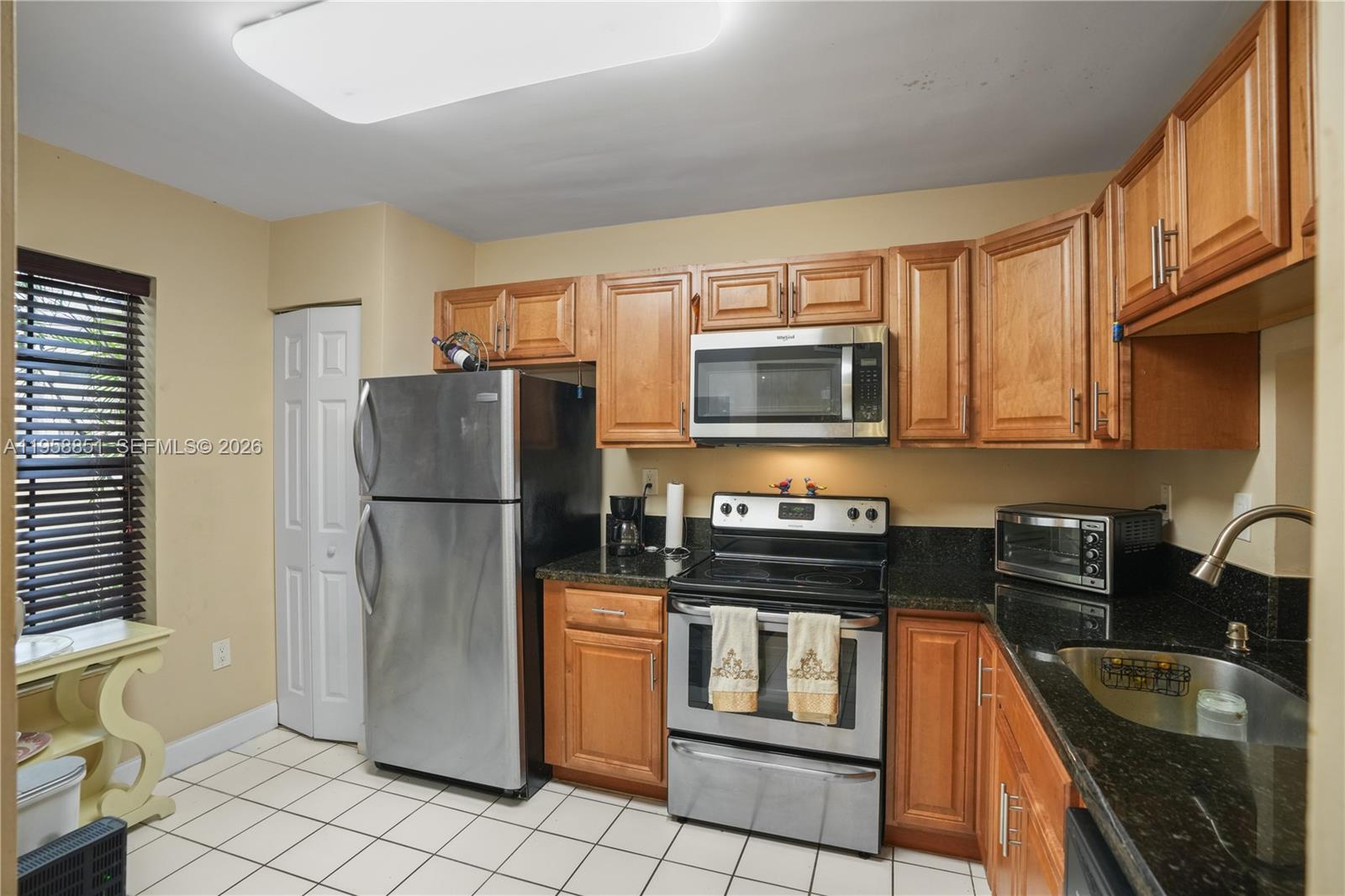 12930 Southwest 88th Terrace, Unit A104 Miami, FL 33186 - Photo 8 of 38 a kitchen with a refrigerator stove and microwave