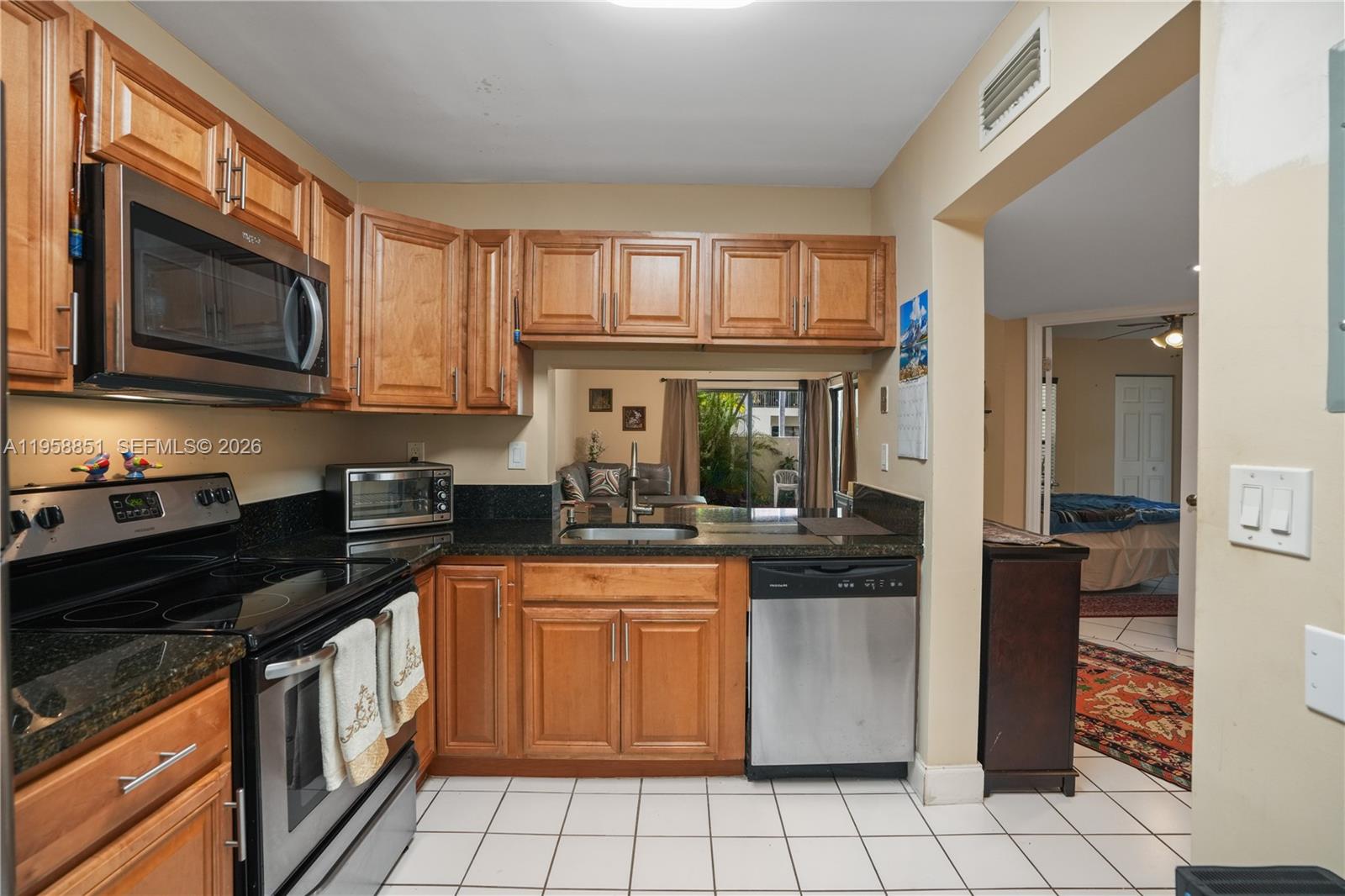 12930 Southwest 88th Terrace, Unit A104 Miami, FL 33186 - Photo 9 of 38 a kitchen with a stove microwave and sink