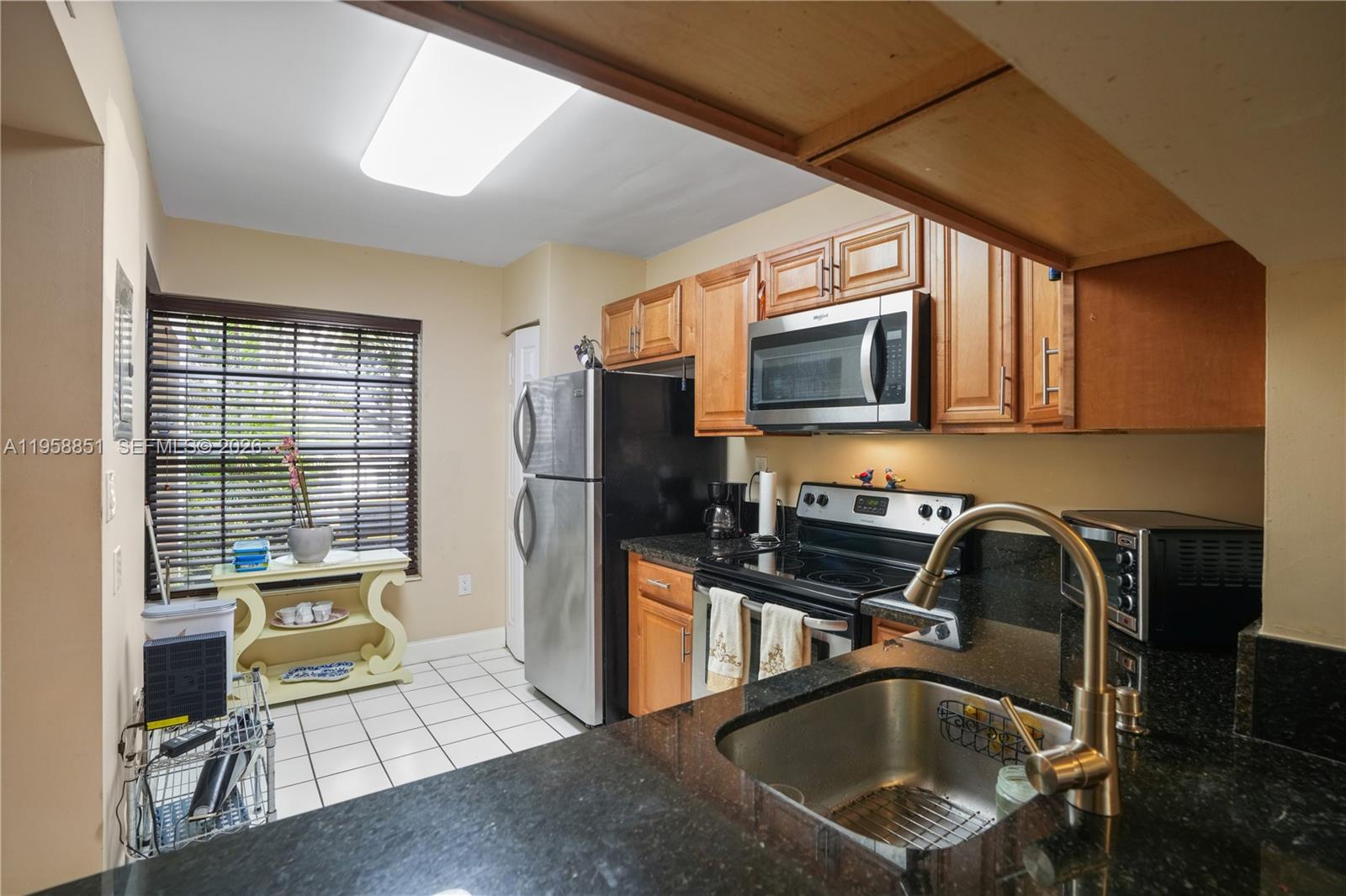 12930 Southwest 88th Terrace, Unit A104 Miami, FL 33186 - Photo 10 of 38 a kitchen with stainless steel appliances a stove a sink and a microwave