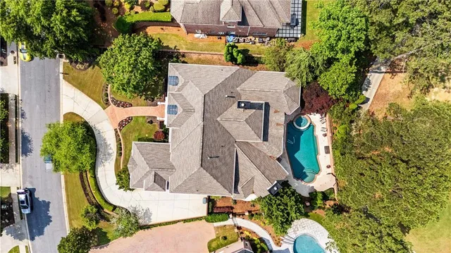 an aerial view of a house with swimming pool and garden