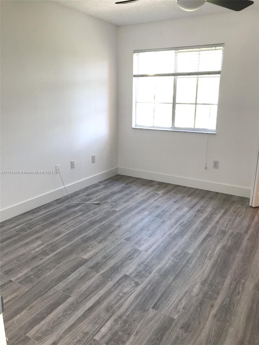 8020 North Nob Hill Road, Unit 208 Tamarac, FL 33321 - Photo 1 of 15 an empty room with wooden floor and windows