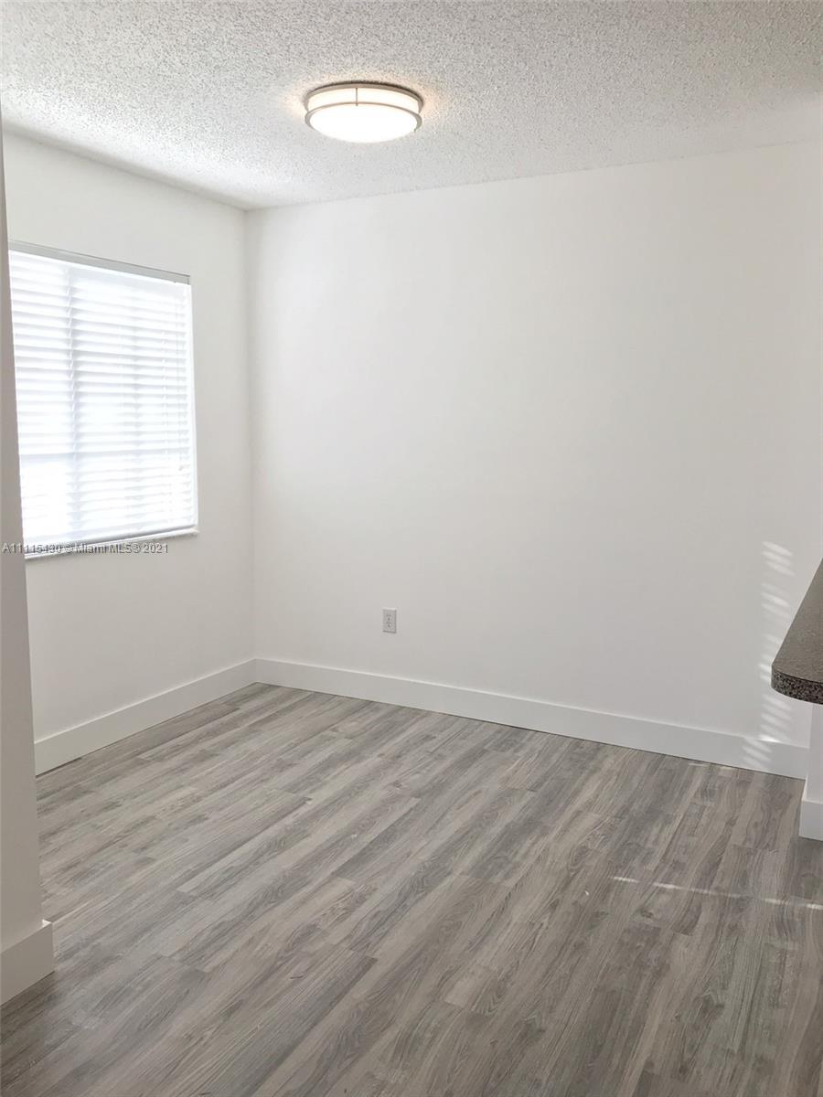 8020 North Nob Hill Road, Unit 208 Tamarac, FL 33321 - Photo 4 of 15 an empty room with wooden floor and windows