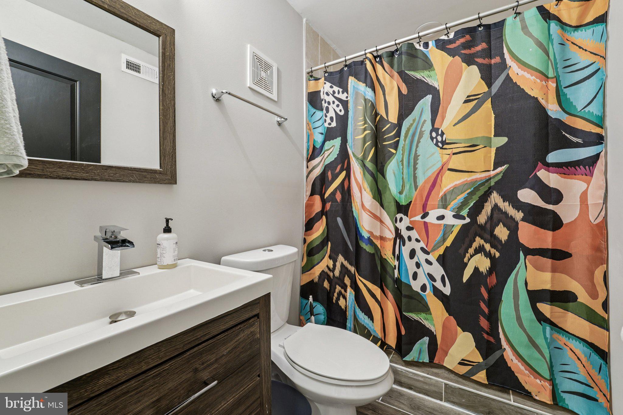 147 North Streeper Street Baltimore, MD 21224 - Photo 15 of 34 a bathroom with a sink a toilet and a mirror